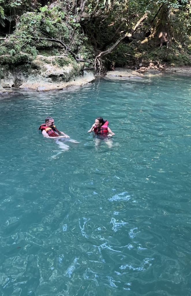 Dua wisatawan berenang mengapung mengenakan rompi pelampung di sungai Citumang