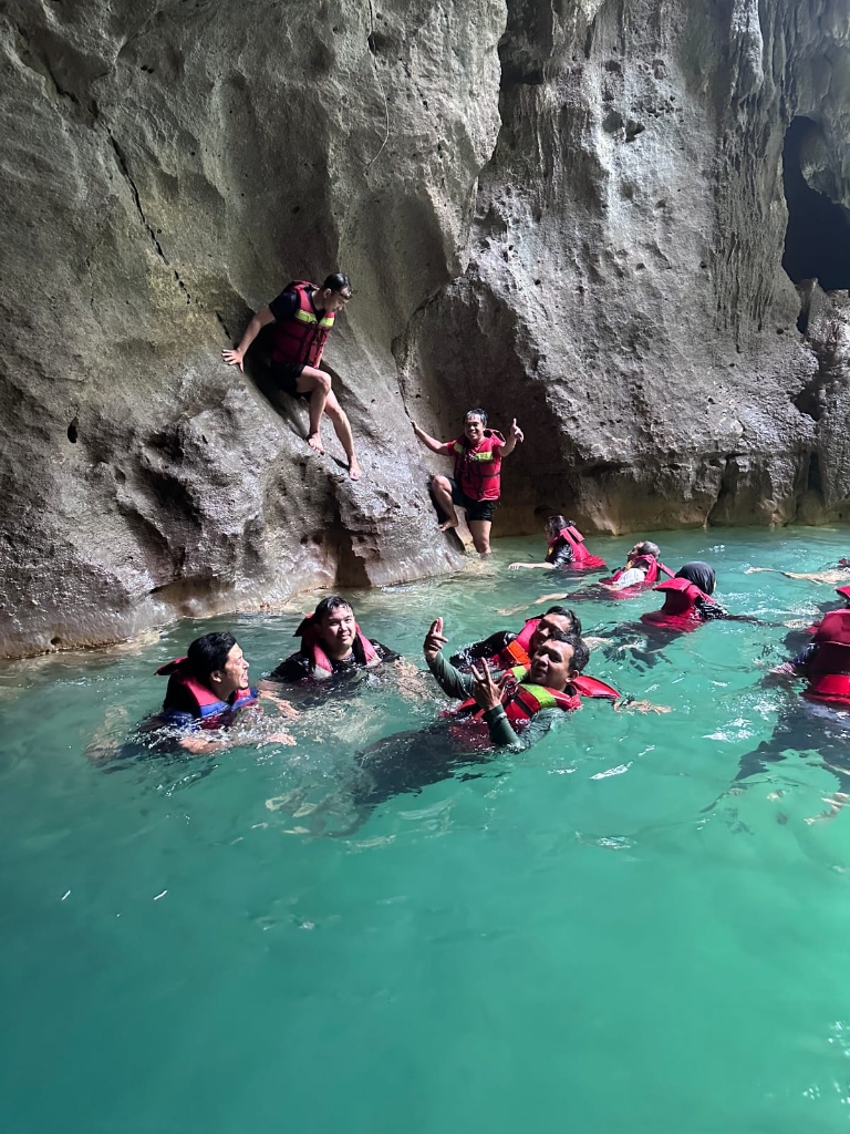 Rombongan wisatawan berpelampung di antara dinding tebing batu karst Citumang